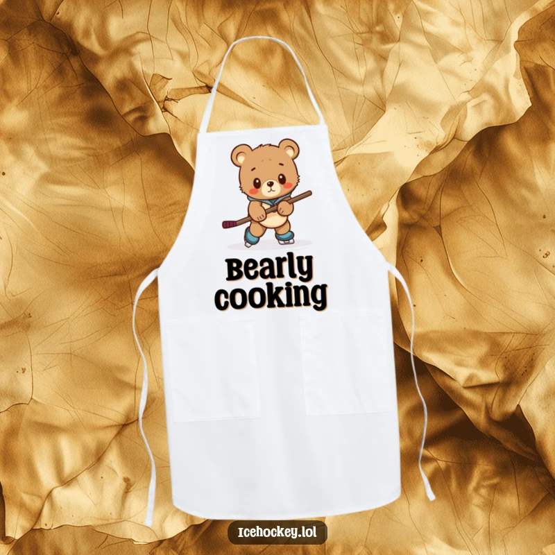 Funny apron depicting a curious bear cub struggling to skate with a comically large hockey stick, for kitchen humor.