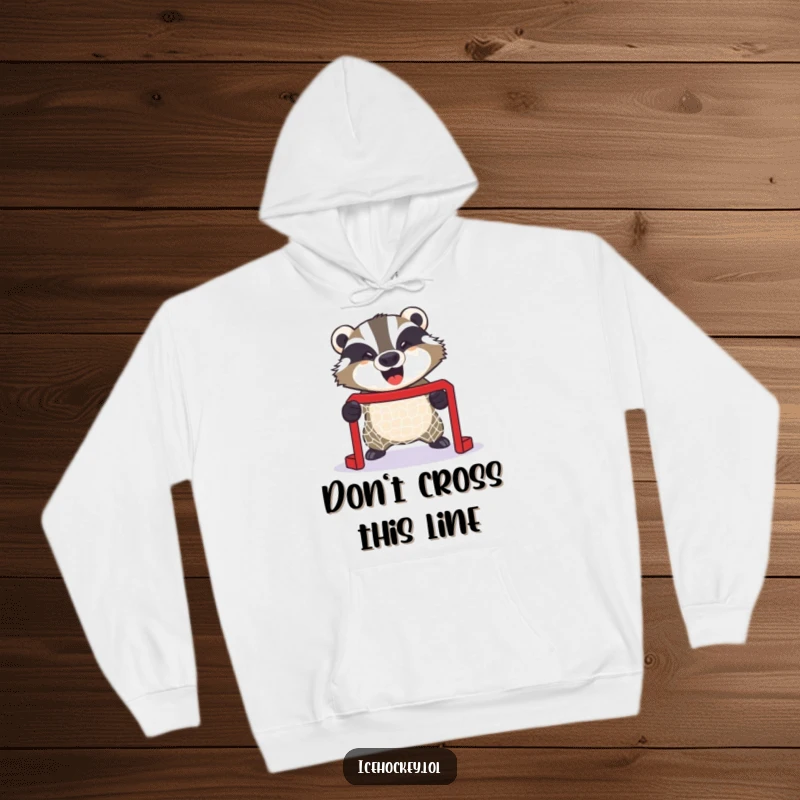 Funny hoodie with a giggling badger intensely guarding a small hockey net, radiating fierce protective energy and humor.