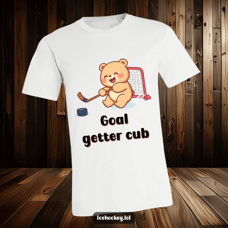 Funny t-shirt featuring a joyful, round bear cub skillfully shooting a hockey puck, illustrating playful sports action.